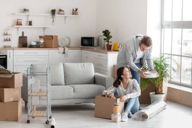 Genç çift taşınma gününde mutfakta.