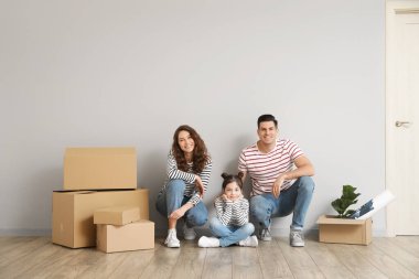 Yeni evlerinde kutuları taşıyan mutlu bir aile.