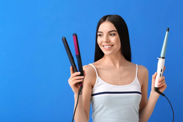 Hermosa Mujer Joven Con Planchas Aplanadoras Rizadoras Sobre Fondo Color —  Fotos de Stock