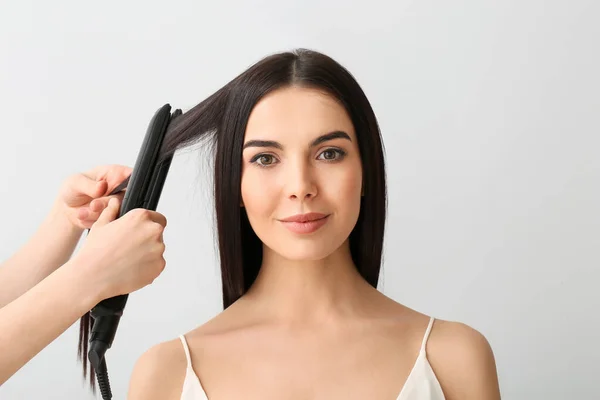 Straightening Young Woman Hair Light Background — Stock Fotó
