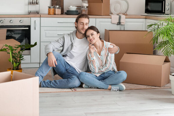 Young couple with cardboard boxes in their new house on moving day