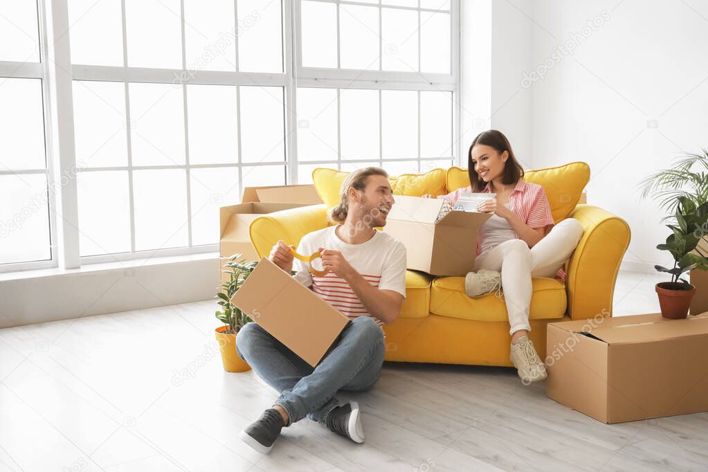 Young couple with belongings in their new house on moving day