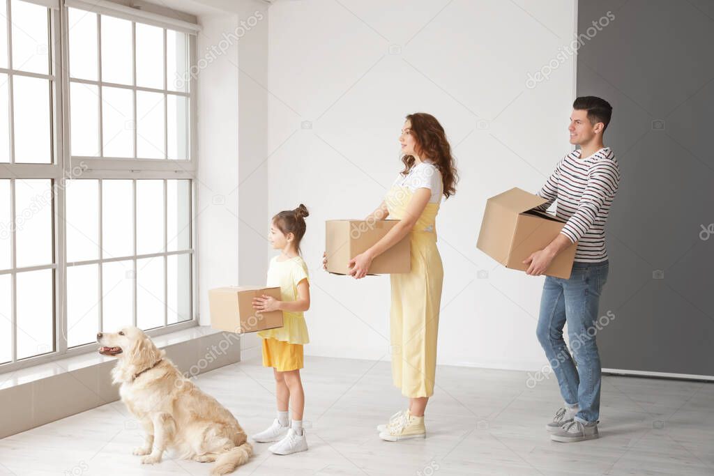 Happy family with dog and moving boxes in their new house