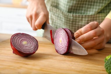 Mutfakta soğan doğrayan kadın, yakın plan.