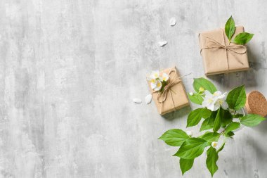 Arkaplanda hediye kutuları ve güzel yasemin çiçekleri olan kompozisyon