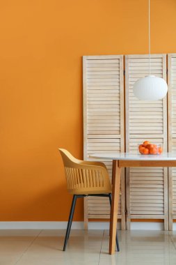 Yemek masası ve katlanan ekran renk duvarının yanında