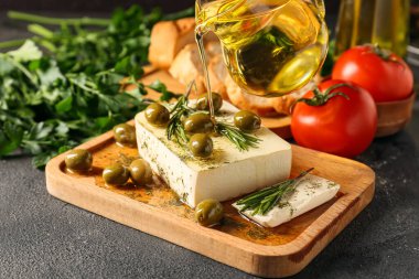 Lezzetli peynirli pano, koyu arkaplanda zeytin ve baharatlar, yakın plan.