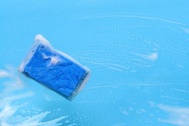 Renk arkaplanında köpük olan temizlik süngeri