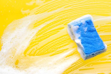 Renk arkaplanında köpük olan temizlik süngeri