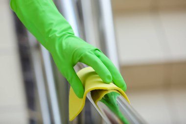 Odanın parmaklıklarını temizleyen kadın, yakın plan.