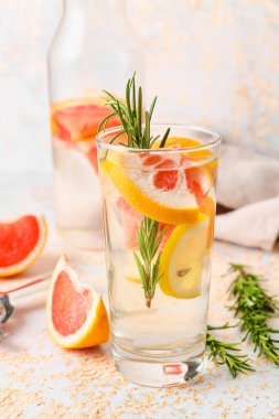 Hafif arka planda biberiyeli bir bardak greyfurt limonatası.