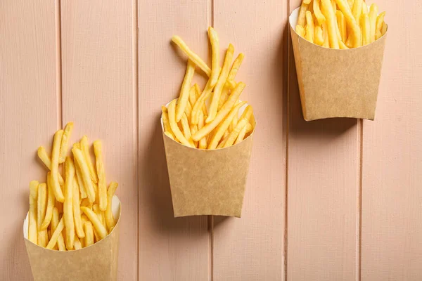 Paper Bags Tasty French Fries Color Wooden Background — Stock Photo, Image