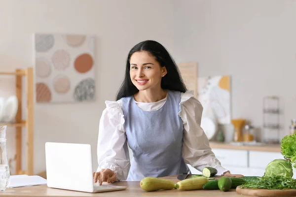 Jeune Femme Utilisant Ordinateur Portable Tout Cuisinant Dans Cuisine — Photo