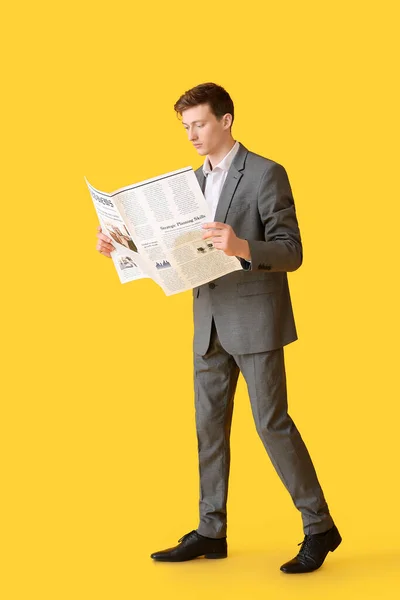 若い実業家は色の背景に新聞を読む — ストック写真