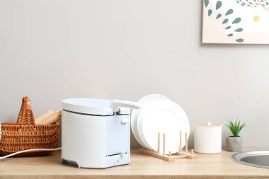 Modern fritöz ve tabaklar mutfakta.