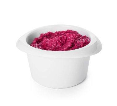 Beyaz arka planda lezzetli pancar humusu olan bir kase.