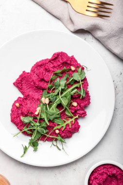 Lezzetli pancar humuslu tabak ve arka planda taze lahanalar, yakın plan.