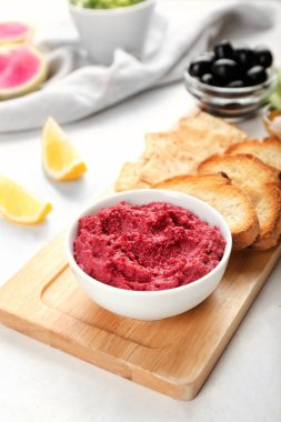 Lezzetli pancar humusu, kraker ve hafif arka planda tost.