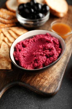 Koyu arkaplanda lezzetli pancar humusu olan kase, yakın plan.