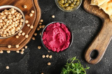 Lezzetli pancar humusu, kapari, taze lahanalar ve koyu arkaplanda nohut karışımı.