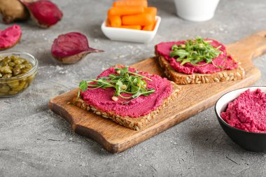 Lezzetli pancar humuslu ekmek ve arkaplanda taze lahanalar.