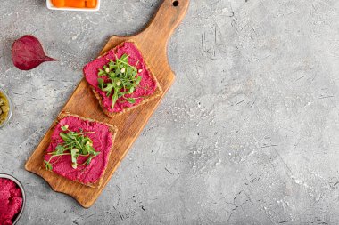 Lezzetli pancar humuslu ekmek ve arkaplanda taze lahanalar.