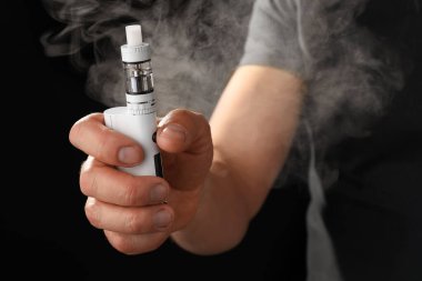 Koyu arkaplanda tütsülenmiş vape modu olan adam, yakın plan