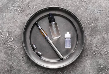 Elektronik sigaralı tepsi ve grunge arkaplanda yağ