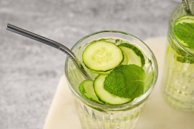 Gri arka planda salatalıklı limonata.