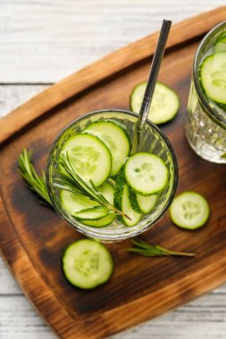 Hafif ahşap arka planda salatalıklı limonata.