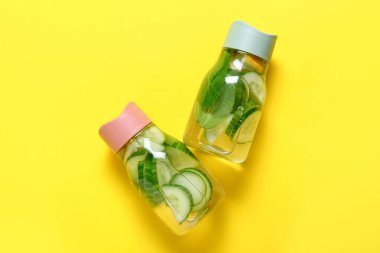 Arka planda salatalıklı limonata şişeleri