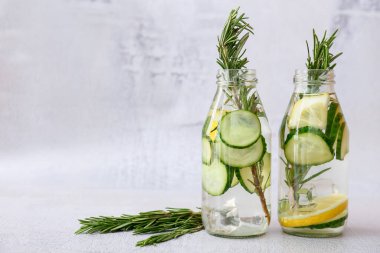 Hafif arka planda salatalıklı limonata şişeleri