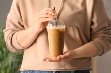 Plastik bardakta lezzetli buzlu kahve tutan kadın, yakın plan.
