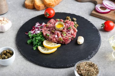 Arkaplanda lezzetli sığır etli tartar tabağı.