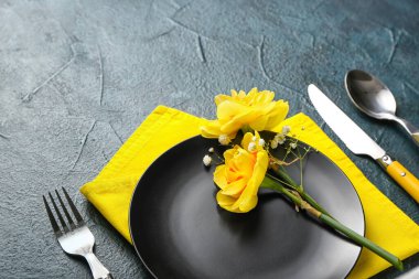 Koyu arkaplanda narsis çiçekleri olan güzel bir masa.