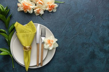 Koyu arkaplanda narsis çiçekleri olan güzel bir masa.