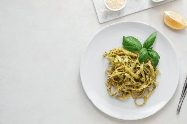 Beyaz arka planda lezzetli pesto makarna tabağı