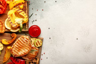 Lezzetli ızgara sebzeler ve hafif arka planda biftekler.