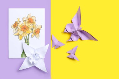 Origami narsisus çiçeği, kelebekler ve renkli arkaplanda tebrik kartı