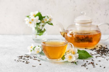 Hafif arkaplanda yasemin çayı ve çiçekli kompozisyon