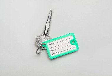 Gri arkaplanda plastik etiketli anahtar