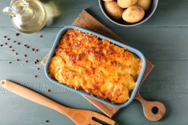 Ahşap arka planda lezzetli patates güveci ile fırın yemeği.