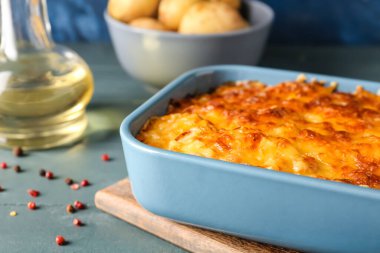Ahşap arka planda lezzetli patates güveci ile fırın yemeği, yakın plan.