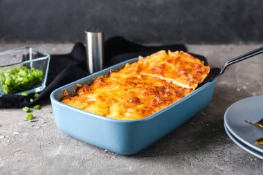 Grunge arka planında lezzetli patates güveci olan fırın yemeği, yakın plan.