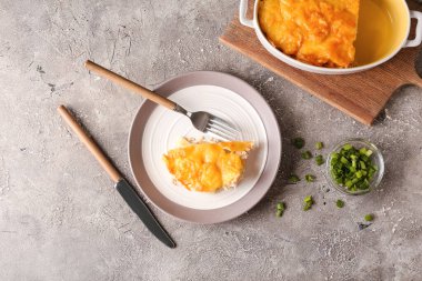 Arkaplanda lezzetli patates güveci olan bir tabak.