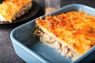 Koyu arkaplanda lezzetli patates güveci olan yemek tabağı, yakın plan.