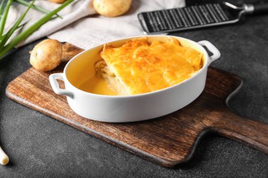 Koyu arkaplanda patates güveci olan fırın yemeği.