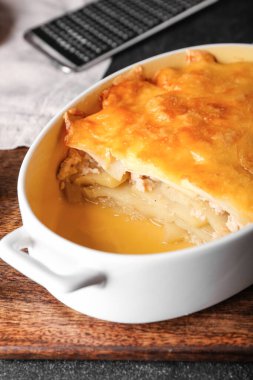 Koyu arkaplanda lezzetli patates güveci olan yemek tabağı, yakın plan.