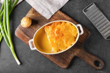 Koyu arkaplanda patates güveci olan fırın yemeği.