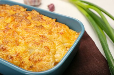 Hafif arka planda lezzetli patates güveci olan fırın yemeği, yakın plan.